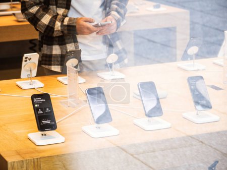 Téléchargez les photos : Paris, France - 22 sept. 2023 : Une main tendue pour tester les fonctionnalités avancées du dernier Apple iPhone 15 Pro Max dans une zone d'affichage des magasins - en image libre de droit