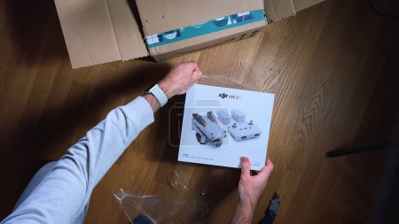 Photo for Paris, France - Sep 22, 2023: An overhead shot captures a male hand unboxing the DJI Air 2S professional drone, revealing its video and photo capabilities for use - Royalty Free Image