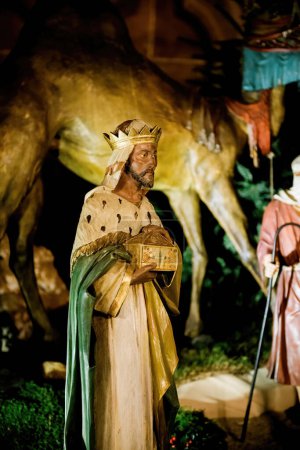 Photo for A solemn statue of a Magi king, part of a Christmas display in Notre-Dame de Strasbourg, set against a backdrop of festive decor - Royalty Free Image