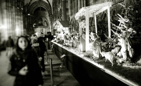 Foto de STRASBOURG, FRANCIA - DIC 23, 2017: Una visión borrosa de los visitantes que observan el belén de Navidad en Notre-Dame de Strasbourg, enfatizando la exhibición estacional - Imagen libre de derechos