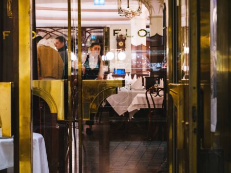 Foto de Estrasburgo, Francia - 25-nov-2022: Un acogedor vistazo a un restaurante con luz cálida en Estrasburgo, Francia, que captura el ambiente y la elegancia de una experiencia gastronómica típica francesa - Imagen libre de derechos