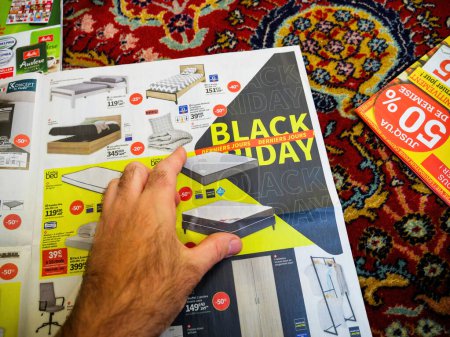 Foto de París, Francia - 12 de diciembre de 2022: Un anuncio que muestra las ventas del Viernes Negro en los muebles, con etiquetas de precios con descuento, capturando la prisa del consumidor por las ofertas - Imagen libre de derechos