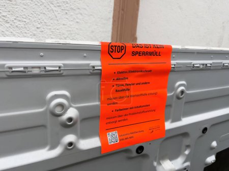 Foto de Frankfurt, Alemania - 28 de enero de 2023: Una señal de advertencia naranja en alemán en un contenedor advierte contra la eliminación inadecuada de residuos electrónicos, lo que refleja las políticas locales de gestión de residuos - Imagen libre de derechos