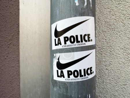 Foto de París, Francia - 1 de octubre de 2023: pegatina de Nike La Police en un muro urbano en Estrasburgo, parte del movimiento antifascista de acción, con desechos públicos pegados por jóvenes rebeldes - Imagen libre de derechos