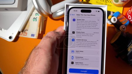 Photo for Paris, France - Sep 23, 2023: Male hand setting up screen time, display zoom, location services, Apple Wallet, and connection to two Apple Watches on a new iPhone - Royalty Free Image
