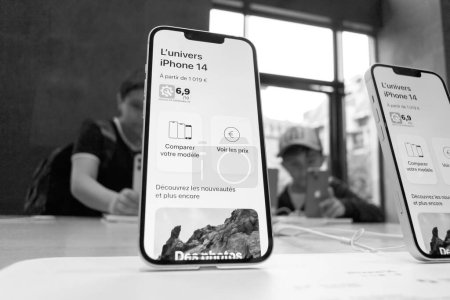 Foto de París, Francia - 22-sep-2022: Una toma heroica del nuevo iPhone 14 en una Apple Store, con los clientes comprando en segundo plano, mostrando la última tecnología y diseño - Imagen libre de derechos