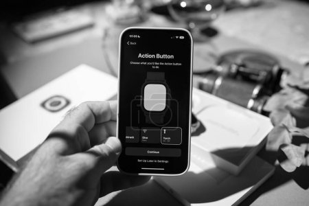 Téléchargez les photos : Londres, Royaume-Uni - 23 sept. 2022 : Une image de déballage en noir et blanc présente la configuration du nouvel Apple iPhone 15 Pro, mettant l'accent sur la configuration du bouton d'action - en image libre de droit