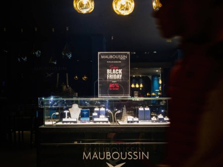 Téléchargez les photos : Strasbourg, France - 25 nov. 2022 : Des silhouettes élégantes de consommateurs se sont rassemblées devant Mauboussin le vendredi noir, profitant d'un généreux rabais de 25 % sur les bagues, bracelets, boucles d'oreilles et autres - en image libre de droit