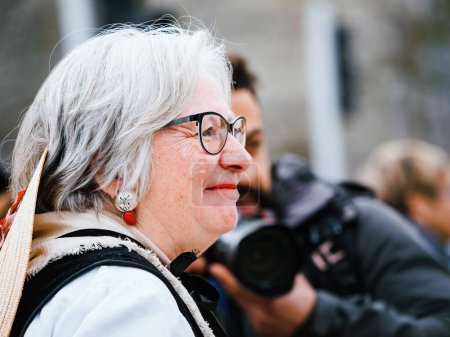 Foto de Estrasburgo, Francia - 29 de marzo de 2023: Smiling senior woman - Las personas mayores suizas protestan pacíficamente frente a la Corte Europea de Derechos Humanos, con pancartas que exigen acción contra el cambio climático - Imagen libre de derechos