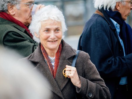 Téléchargez les photos : Strasbourg, France - 29 mars 2023 : Elégante femme âgée confiante avec des antécédents déconcentrés pf d'autres seniros protestent pacifiquement devant la Cour européenne des droits de l'homme, tenant des pancartes comme - en image libre de droit