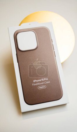 Foto de París, Francia - 3 de noviembre de 2023: Foto de cambio de inclinación del embalaje de cartón para Apple iPhone 15 Pro estuche de protección finewoven sobre un fondo dorado - Imagen libre de derechos