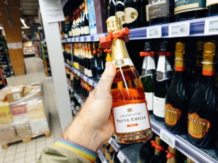 Foto de París, Francia - 10-nov-2023: Gran punto de vista de un hombre que selecciona Veuve Emille Brut, un lujoso champán francés, en un supermercado, destacando una opción para bebidas premium - Imagen libre de derechos