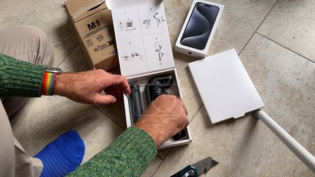 Photo for Paris, France - Jun 10, 2023: POV overhead view of a male hand unboxing the new DJI Osmo Mobile 6 smartphone stabilizer from its cardboard packaging - Royalty Free Image