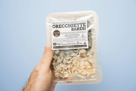 Foto de Paris, France - Dec 20, 2023: A male hand holds a package of Orecchiete Baresi pasta manufactured by Marziale, with the contents perished and covered in mold - Imagen libre de derechos