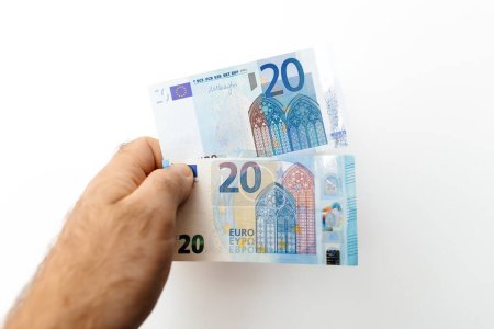Foto de París, Francia - 31 de octubre de 2023: Dos billetes de 20 euros sobre un fondo de pared blanca, ilustrando el concepto de préstamos financieros, préstamos de dinero y donaciones - Imagen libre de derechos