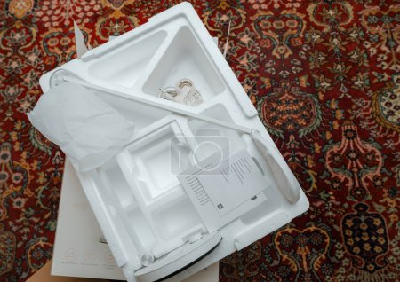 Foto de París, Francia - 15-nov-2023: El paquete de poliestireno de la lámpara de escritorio Mi Smart led Pro, recién sin caja, se muestra en una alfombra de sala de estar. - Imagen libre de derechos
