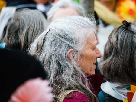 Photo for Strasbourg, France - Mar 29, 2023: Side view of a gray-haired senior woman among a group of Swiss seniors at the European Court for Human Rights, peacefully protesting climate change. - Royalty Free Image