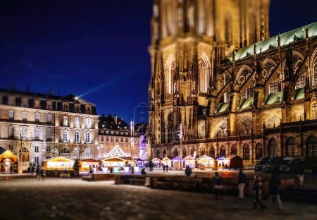 Photo for Holiday spirit as a bustling market glows beneath a Gothic cathedral under the starlit evening sky, creating a magical atmosphere - Royalty Free Image