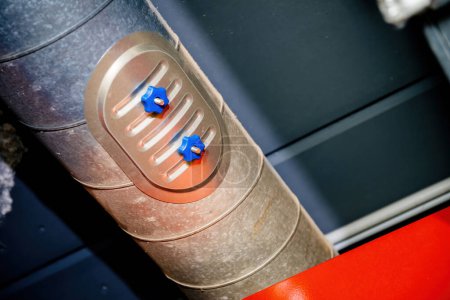 Foto de Primer plano detallado de dos controles de válvulas industriales azules incrustados en una superficie metálica, que muestran componentes mecánicos modernos. - Imagen libre de derechos