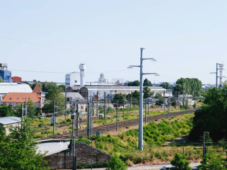 Téléchargez les photos : Un chemin de fer se déplace gracieusement le long des voies ferrées à côté d'un champ vert animé et luxuriant de Strabourg, France à Kehl, Allemagne - en image libre de droit