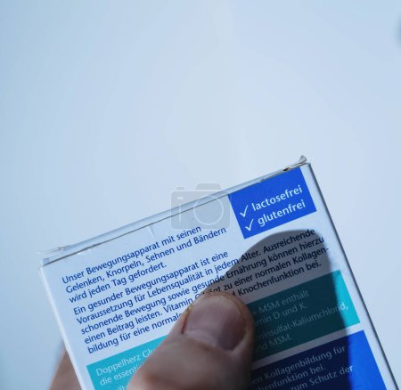 Téléchargez les photos : Francfort, Allemagne - 12 juin 2023 : Plan rapproché d'une main tenant une étiquette transparente allemande, mettant en évidence l'information nutritionnelle sur un fond lumineux sans lactose et - en image libre de droit