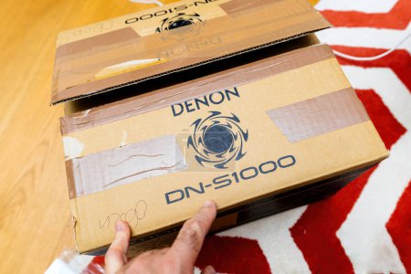 Photo for Paris, France - Oct 24, 2023:A person is in the process of unboxing a Denon DN-S1000 DJ CD player, with the cardboard packaging partially opened to reveal the equipment inside. - Royalty Free Image