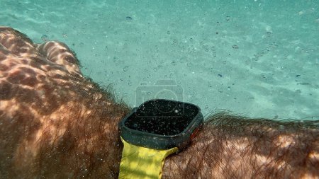 Téléchargez les photos : Mallorca, Espagne - 27 août 2023 : Apple Computers Watch Ultra 2 Smartwatch au poignet poilu immergé dans de l'eau de mer turquoise claire - en image libre de droit