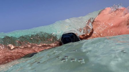 Téléchargez les photos : Une vague flotte au-dessus de l'Apple Watch Ultra 2 en plongeant dans la mer bleue profonde, capturant une aventure aquatique avec une technologie de pointe - en image libre de droit