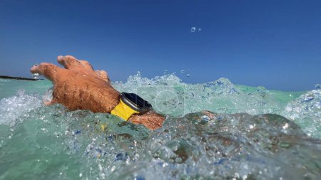 Foto de Una fotografía única de un buceo masculino con el Apple Watch Ultra Series 2 bajo un cielo azul claro, que combina unas vacaciones perfectas y natación de entrenamiento - Imagen libre de derechos