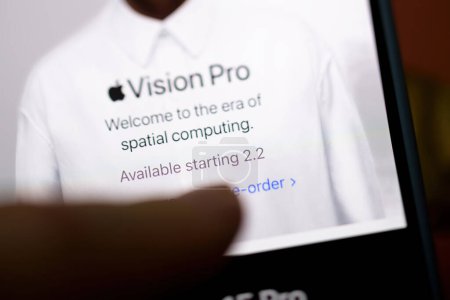 Photo for California, USA - Jan 21, 2024: A finger points to the retina screen with a tilt-shift lens, highlighting the message about the Vision Pro era starting on February 2, with options to learn more and - Royalty Free Image