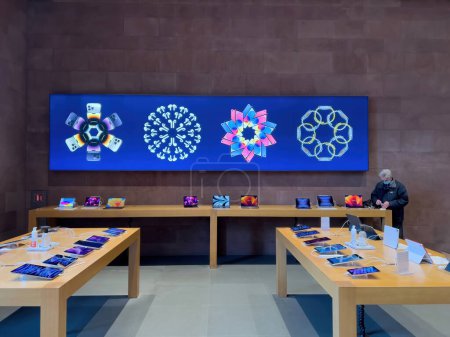 Photo for Paris, France - Dec 19, 2022: Customers inside Apple Computers store selling iPads, iMacs, Macbook Pro and iPhones and other home technology equipment decorated for winter holiday - Royalty Free Image