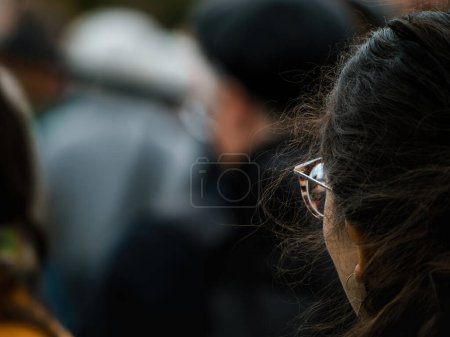 Foto de Vista trasera de una mujer irreconocible con gafas de lujo en un entorno urbano lleno de gente - Imagen libre de derechos