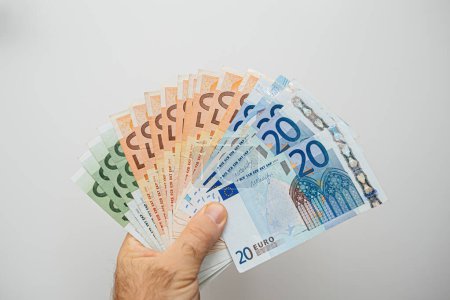 Téléchargez les photos : Une personne tient un tas d'argent dans sa main. - en image libre de droit
