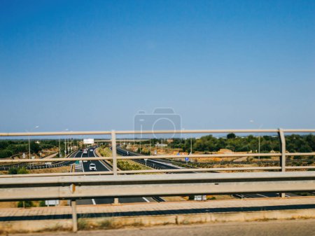 Téléchargez les photos : Un ciel bleu clair surplombant les voitures sur l'asphalte de la route principale à Majorque, Espagne, du point de vue d'un pont - en image libre de droit