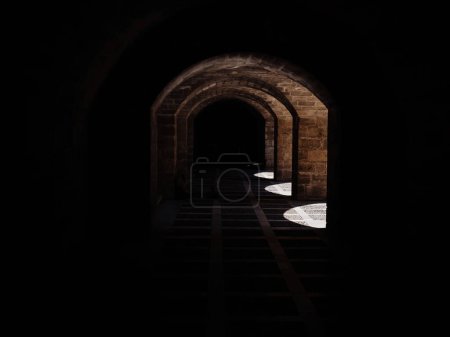 Téléchargez les photos : Découvrez l'enchantement d'un tunnel sombre avec un faisceau de lumière captivant à son extrémité à Majorque, Palma de Majorque, Espagne, entouré par la magnifique architecture de Catedral-Baslica de Santa - en image libre de droit