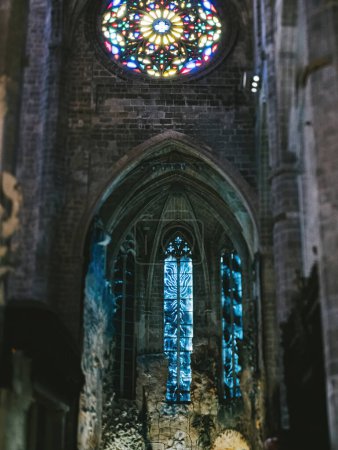 Téléchargez les photos : Une vue intérieure de la Catedral-Basilique de Santa Maia à Palma de Majorque, mettant en valeur les détails gothiques complexes et les vitraux colorés sous une douce lumière du soir. - en image libre de droit