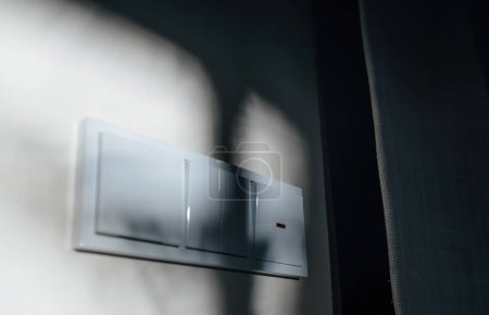 Téléchargez les photos : Une image visuellement agréable présente plusieurs interrupteurs de lumière de conception allemande montés sur un mur, magnifiquement éclairés par la lumière du soleil - en image libre de droit