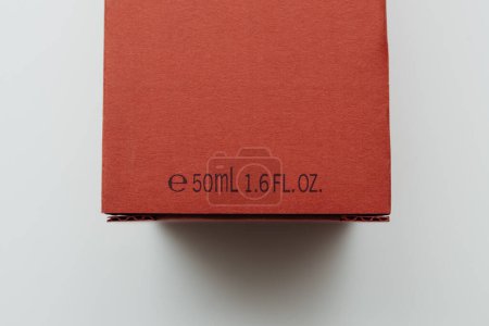 Foto de Una caja de perfume roja que muestra la información del volumen, marcada como 50ml o 1.6 fl. oz., sobre un fondo blanco limpio - Imagen libre de derechos