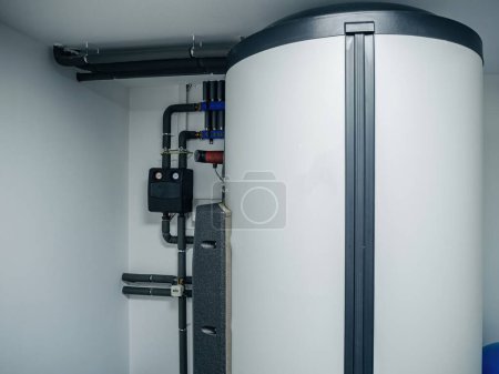 Photo for A contemporary heating system with a high-efficiency water tank, integrated into a clean and organized utility room - Royalty Free Image