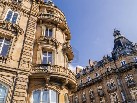Téléchargez les photos : Une façade opulente avec des balcons ornés incarne l'investissement de luxe dans l'immobilier, face à un ciel clair et vaste - en image libre de droit