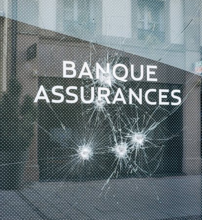 Foto de Una vista de cerca del texto de Bank and Insurance con cristales rotos en la sucursal del banco después de una protesta en Grand Est, Francia, enfatizando los detalles del vidrio roto y la señalización - Imagen libre de derechos