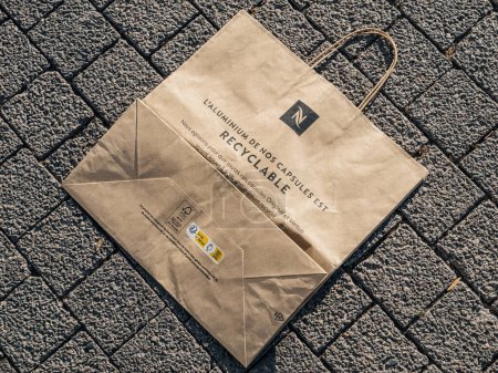 Photo for Strasbourg, France - Jul 2, 2023: An act of littering with a Nespresso paper bag on a cobblestone road, highlighting the need for environmental protection - Royalty Free Image