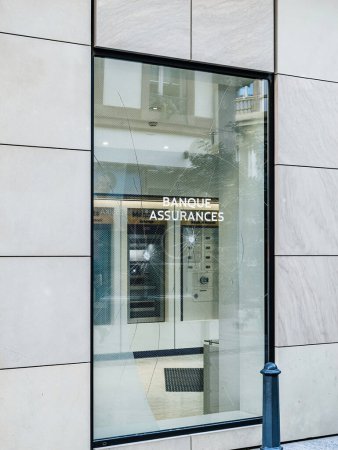 Una vista desde la calle de una sucursal del banco escaparate de cristal que muestra el texto Banco y Seguros en francés, con su vidrio roto después de una protesta en Francia, mostrando las secuelas de la