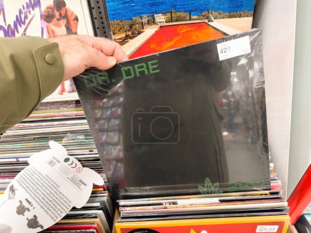 Foto de Berlín, Alemania - 18 de enero de 2024: Una toma POV de una mano masculina comprando un vinilo de LP de música Dr. Dre en una icónica tienda de discos dentro de la tienda de música. - Imagen libre de derechos