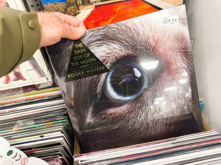 Photo for Berlin, Germany - Jan 18, 2024: A POV shot of a male hand engaged in buying and shopping for the vinyl record The Dark Side of the Moon by Pink Floyd, featuring the music of Roger Waters, in - Royalty Free Image
