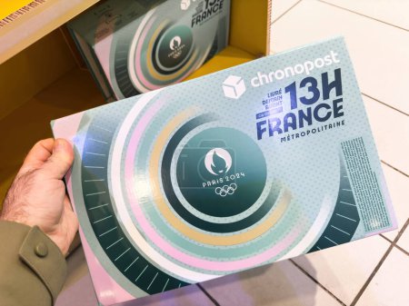 Foto de París, Francia - 19 de enero de 2024: Un hombre compra la caja de entrega oficial de paquetes olímpicos de París 2024 en una oficina postal francesa con entrega de 13 horas en Francia - Imagen libre de derechos