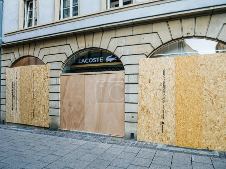 Téléchargez les photos : Strasbourg (France) - 2 juil. 2023 : Un magasin Lacoste sécurisé par des panneaux de contreplaqué au-dessus des fenêtres pour plus de sécurité. - en image libre de droit