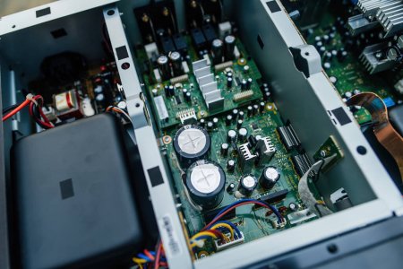Vista de primer plano de un potente circuito de amplificador de música con grandes condensadores y condensadores, en reparación para mejorar la calidad del sonido.