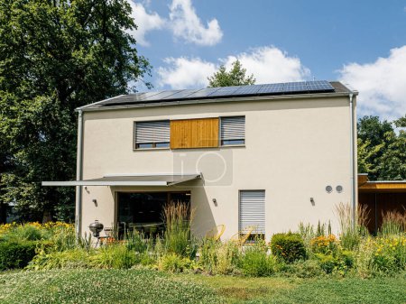 Foto de Una casa ecológica contemporánea con paneles solares y un jardín vibrante en una zona suburbana. - Imagen libre de derechos