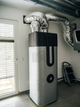 Téléchargez les photos : Système résidentiel de chauffage et de ventilation avec grand réservoir d'eau et conduits dans une buanderie. - en image libre de droit